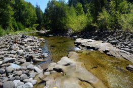 Exposed bedrock in the Teanaway River forms flutes and grooves — depressions where gravel gets trapped in a pothole and erodes it further. The oblong depressions are popular summer bathing spots.