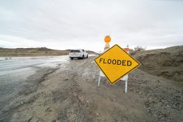 a yellow flood sign sitting on the side of a road