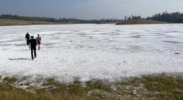 people walk across a lake that has a salty crust